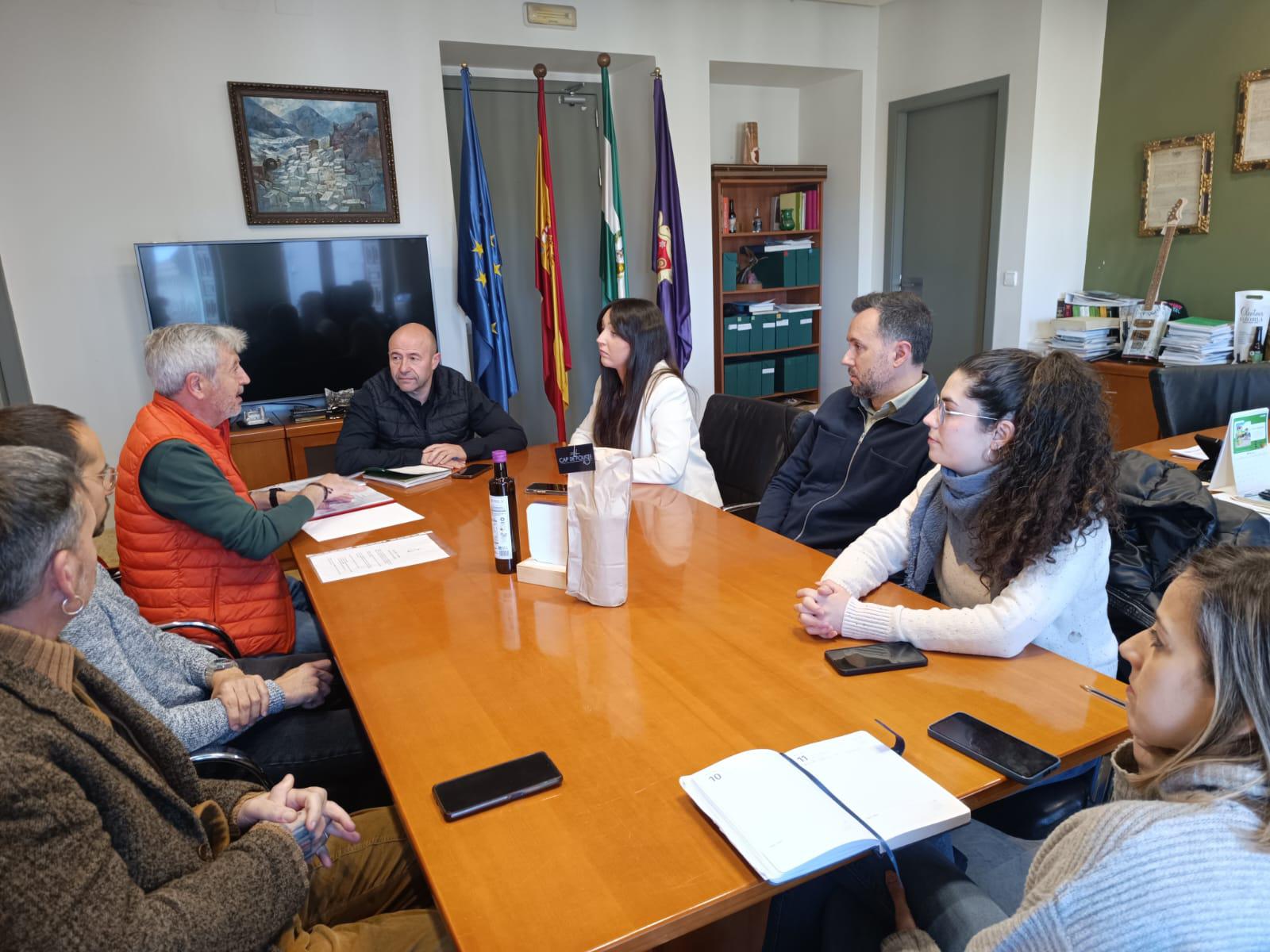 La diputada María Dolores Ruiz se reúne con el alcalde de Cazorla y miembros de colectivos LGTBI alrededor de una mesa de conferencias para planificar la programación de 2026.