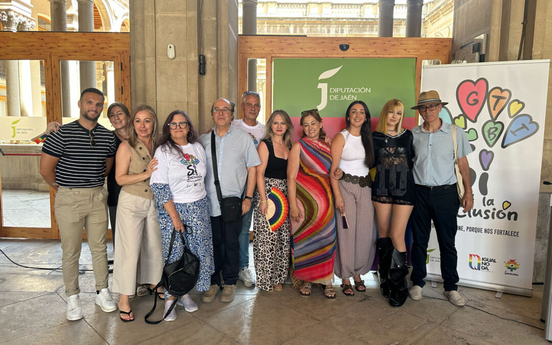 Grupo de asistentes y representantes institucionales posando juntos en la jornada por el Orgullo LGTBIQ+ de la Diputación de Jaén, junto a carteles a favor de la inclusión y la diversidad.