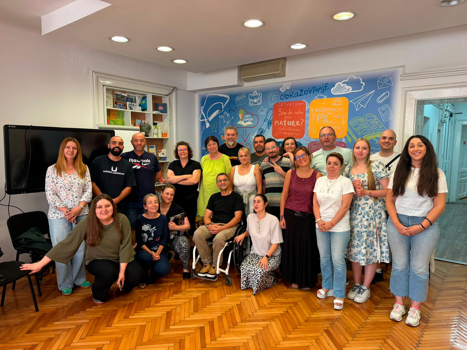Grupo de asistentes al seminario internacional Gems of Brocolink en Serbia, incluyendo a la delegación de juventud de la Diputación de Jaén, posando en una sala de reuniones.